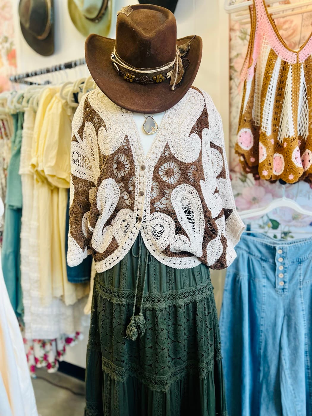 A crochet cardigan and western hat on a mannequin