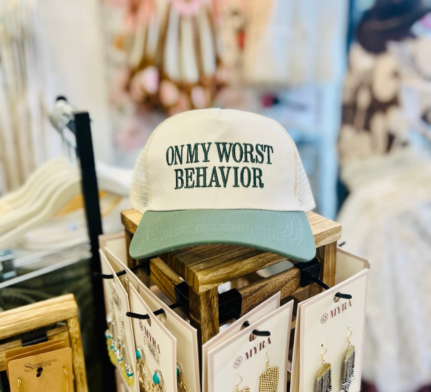 An embroidered trucker hat on a jewelry display