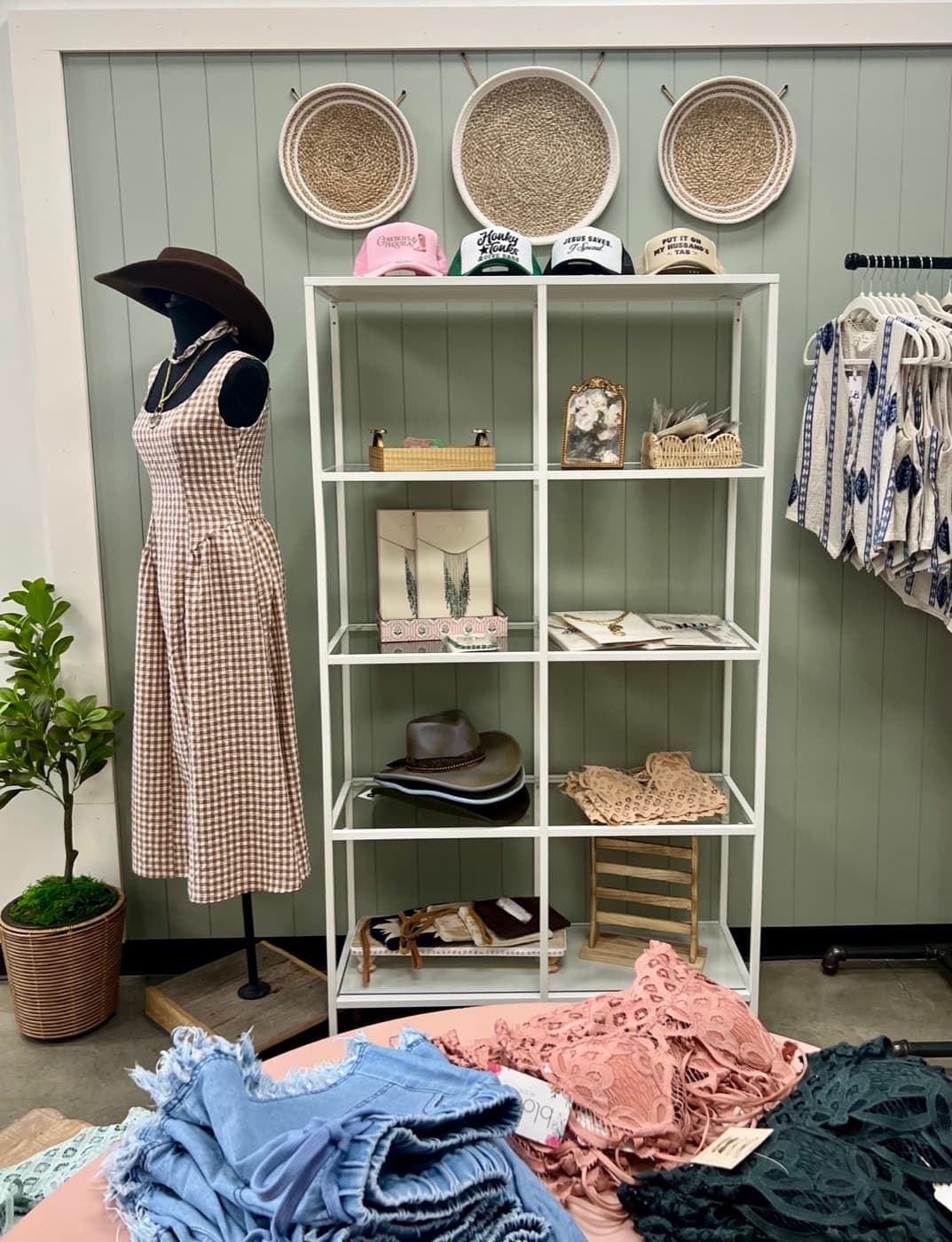 A styled shelf display with hats, baskets, and accessories